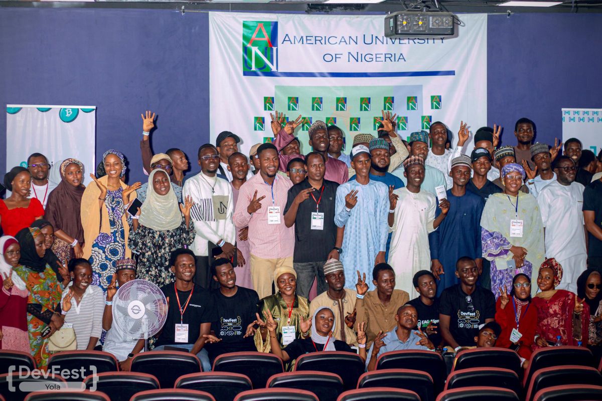 A large group of students and organisers posing together at American University of Nigeria